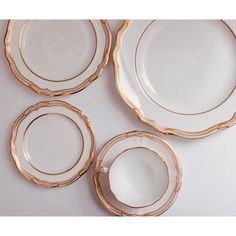 four white and gold plates on a table