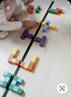 a child playing with wooden blocks on the floor