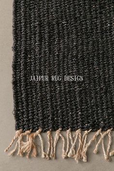 a black and white rug with fringes on the bottom is shown in close up