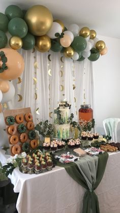 a table topped with lots of desserts and balloons