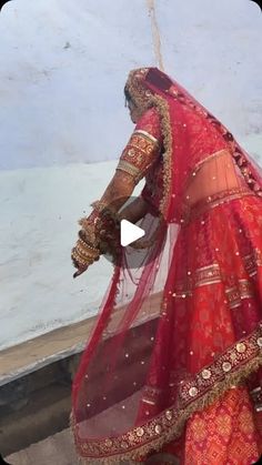 a woman in a red and gold bridal outfit