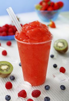 a smoothie with strawberries and kiwi on the side