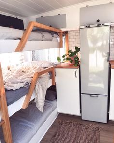 a bunk bed in the corner of a room with a refrigerator and rug on the floor