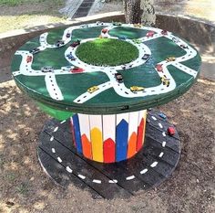 a wooden table with cars and roads painted on it in the shape of a circle