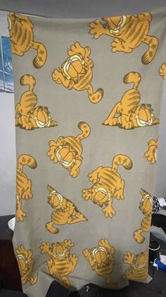 a yellow and gray towel with cartoon cats on it sitting on a desk next to a computer keyboard