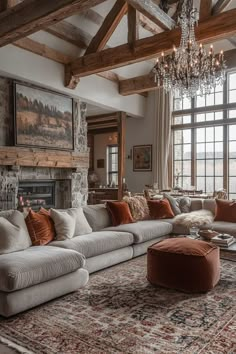 a living room filled with lots of furniture and a chandelier hanging from the ceiling