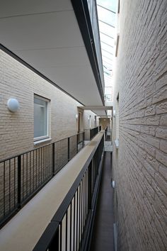 an empty hallway between two buildings with balconies