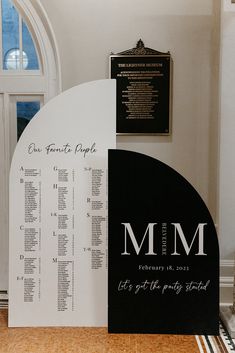 a black and white wedding seating plan on display in front of a church entrance door