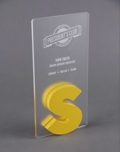 a glass award with the letter s on it's front and bottom side, in yellow