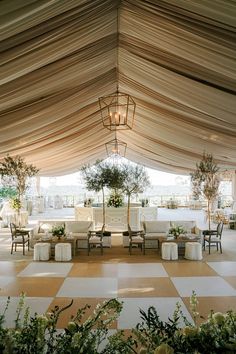 the inside of a tent with tables and chairs