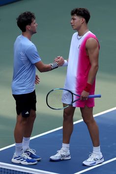 two tennis players shake hands on the court