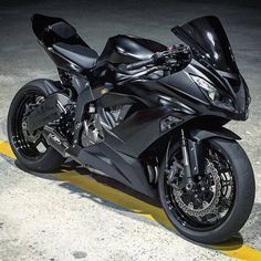 a black motorcycle parked on top of a yellow strip