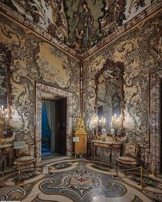 an ornately decorated room with mirrors and chandeliers on the walls, painted in gold