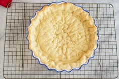 an uncooked pie sitting on top of a cooling rack next to a red pepper