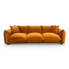 an orange couch sitting on top of a white floor