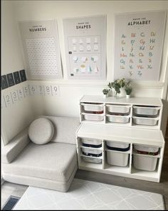 a room with white furniture and posters on the wall