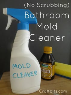 a bottle of mold cleaner sitting on top of a wooden table next to a sponge