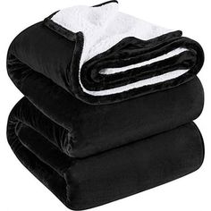 three black and white blankets stacked on top of each other, with one folded up