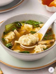 a white bowl filled with dumplings and vegetables