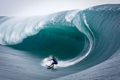 a man riding a wave on top of a surfboard