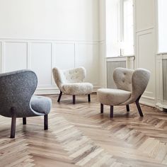 three chairs and one ottoman in a room