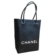 This stylish Chanel mini shopper tote bag is crafted of calfskin leather in black with letters CHANEL in white fabric sewn on the front. Karl Lagerfeld once admitted to collecting chic paper bags which made him decide to immortalize the iconic paper shopper bags. These Chanel shopper totes were also featured on Chanel Spring/Summer Runway in 2009. This mini tote features rolled leather handles that open to an interior lined with black and white jacquard embroidered with Chanel’s iconic symbols. Chanel Shopper, Summer Runway, Iconic Symbols, Shopper Bags, Chanel Mini, Chanel Spring, Shopper Tote, Mini Tote, Paper Bags