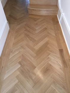 an empty room with wood flooring and white trimmings on the door way