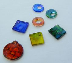 seven different colored glass beads arranged on a white surface