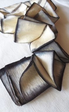 several pieces of glass sitting on top of a white cloth covered table with black edges