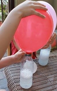 a person holding up a blow it up balloon with water and baking soda in it