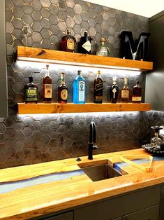 the kitchen counter is lined with liquor bottles