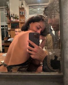 a woman is taking a selfie with her cell phone in front of a mirror