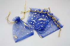 two blue bags with gold stars and moon designs on them, one is tied to a string