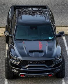 the front end of a black truck parked in a parking lot