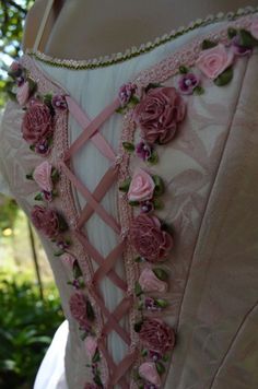 the back of a dress with pink flowers on it, and lace trimmings