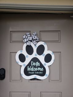 a dog's welcome sign hangs on the front door