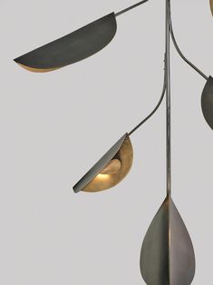 three lights hanging from a metal pole on a gray background, one light is yellow and the other is grey