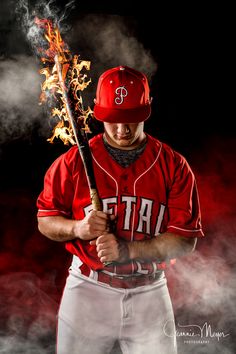 a baseball player holding a bat with fire coming out of his mouth and wearing a red hat