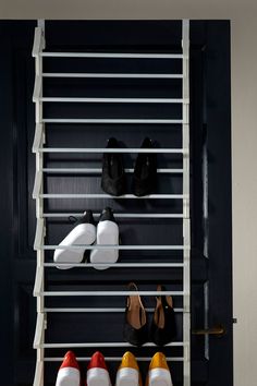 there are many pairs of shoes hanging on the rack in front of the closet door