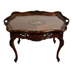 an ornate wooden table with glass top