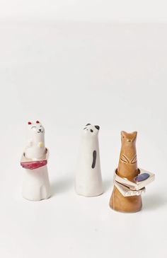 three figurines of cats sitting next to each other