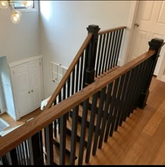 the stairs in this house are made of wood and wrought iron with black handrails