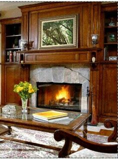 a living room filled with furniture and a fire place in the middle of a fireplace