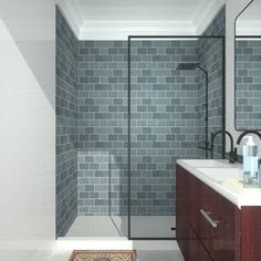 a bathroom with gray brick walls and white counter tops, along with a shower stall