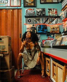 a woman sitting on the floor in front of a record store