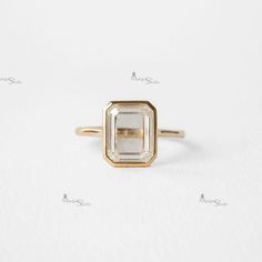 an engagement ring with a square cut diamond in the center, on a white background