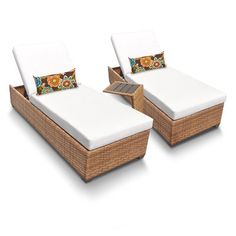 two wicker lounge chairs with white cushions and floral pillow on the back, side by side