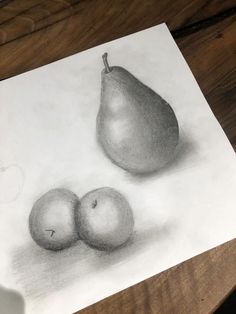 a pencil drawing of two pears and an apple on a piece of paper sitting on a table