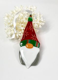 an ornament shaped like a santa hat on top of a table next to white flowers