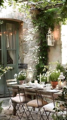 an outdoor dining area with chairs, table and potted plants